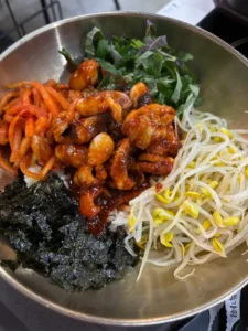 봄동을 활용한 겉절이, 무침, 비빔밥 요리 과정과 완성된 상차림을 설명하기 위해 쓰인 비빔밥 이미지. 온갖 산해진미가 다 들어있는 실물 사진