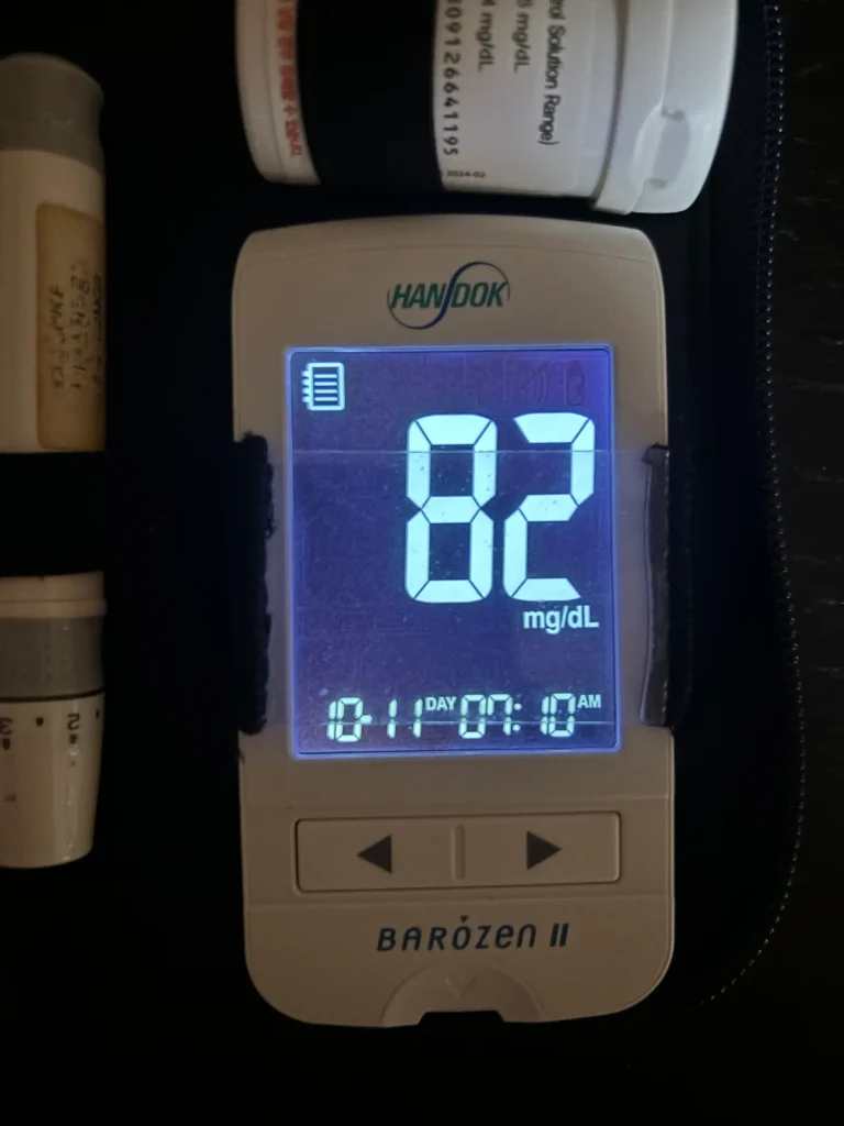 당뇨 환자의 식단 관리 후 다음 날 아침 공복혈당 측정기 화면에 82 mg/dL이 표시된 인증 사진